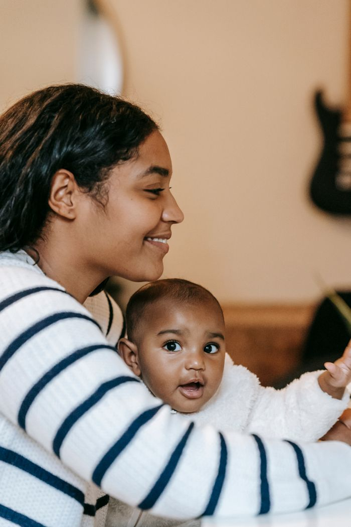 our-experience Happy ethnic mother and child in casual outfit spending time near table at bright home